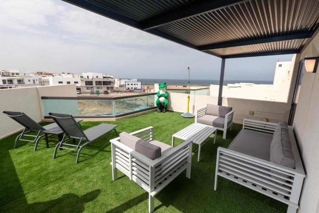 a balcony with chairs and a green creature on a roof at LOLA'S HOME in Cotillo
