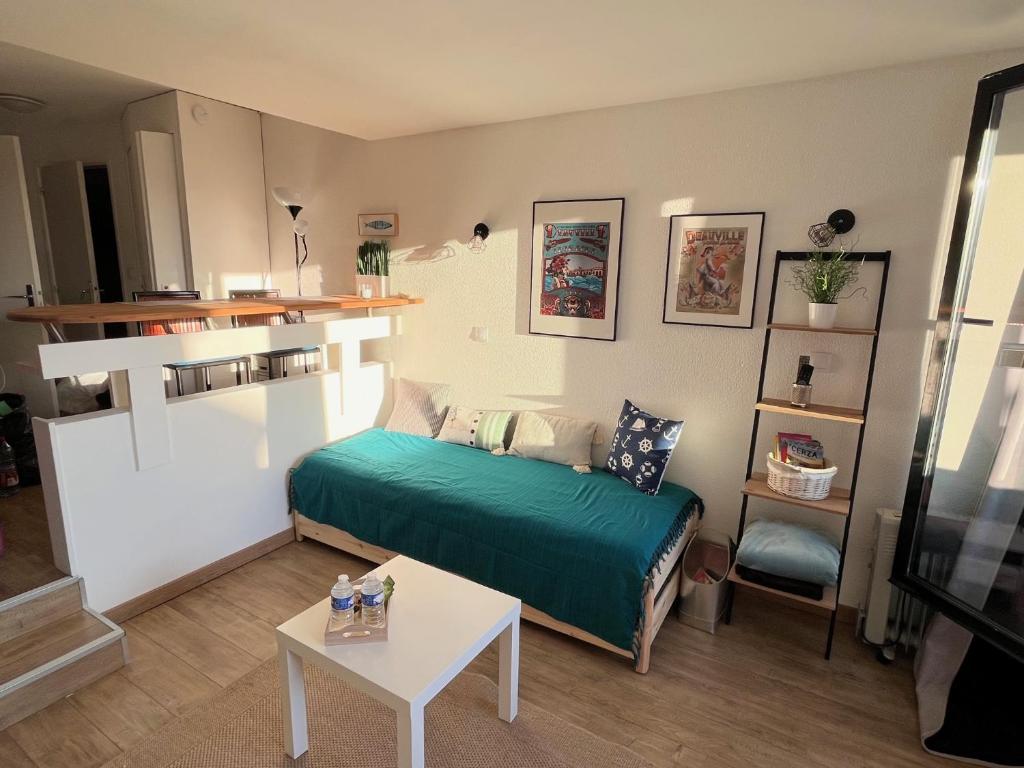 Cette petite chambre comprend un lit et une table. dans l'établissement Appartement La Marina Deauville, à Deauville
