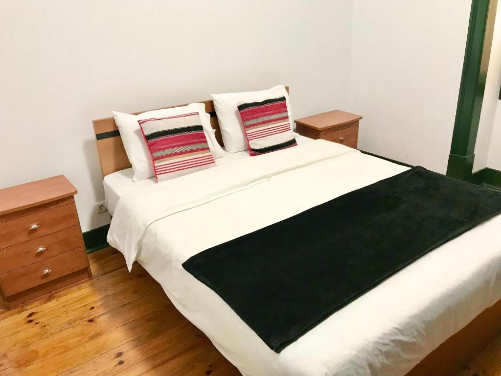 1 dormitorio con 1 cama blanca grande y 2 almohadas en Sublime Black Bedroom, en Lisboa