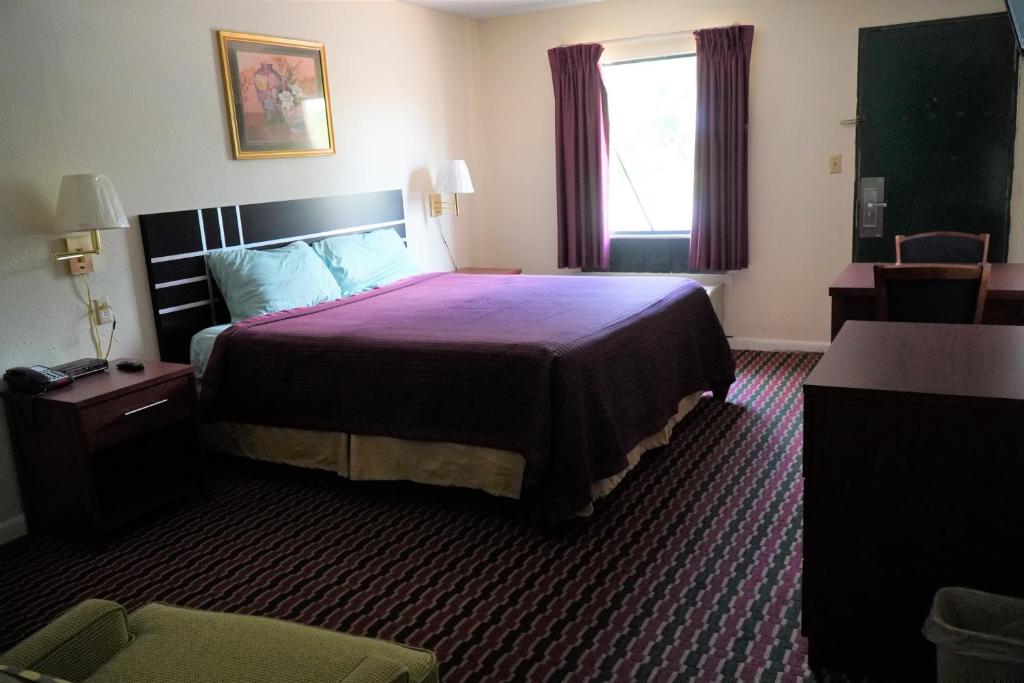 Habitación de hotel con cama grande y ventana en Quality Quarters Inn, en Richmond