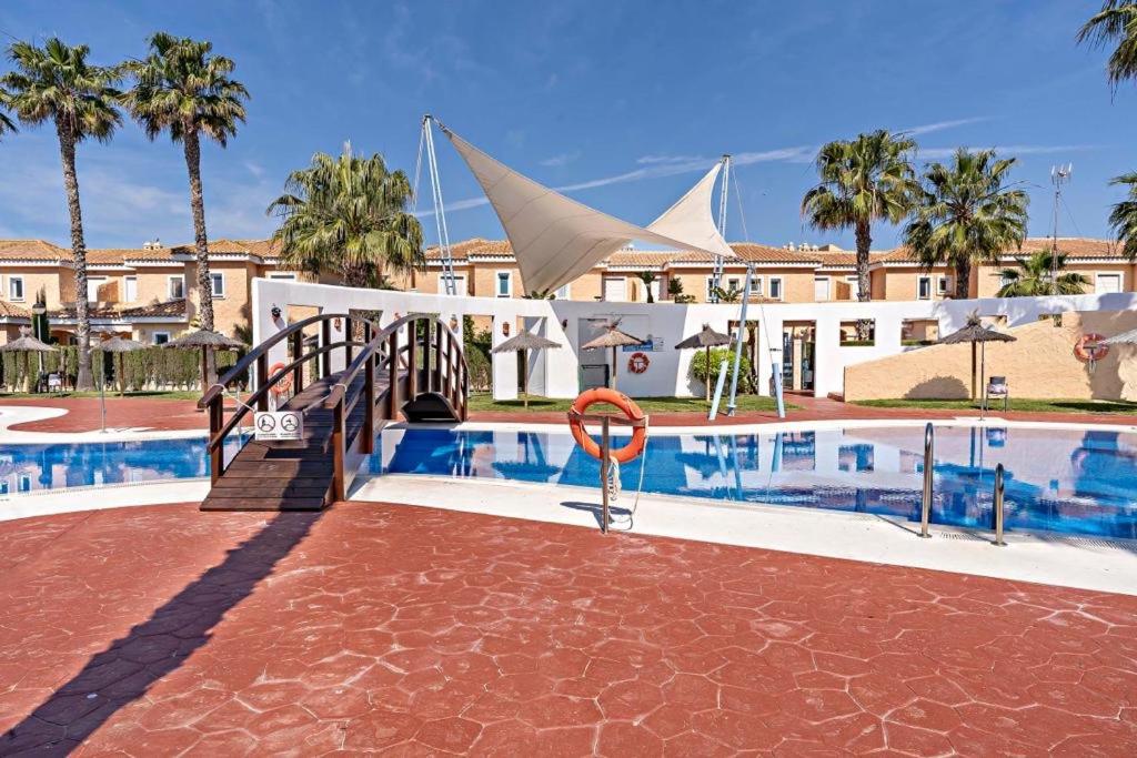 una piscina del complejo con un salvavidas junto a un edificio en Cielo Sur Vera Playa, en Vera