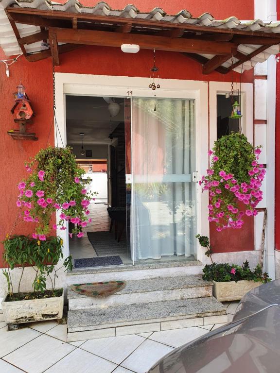 a house with pink flowers on the front door at Cantinho dos Dalto in Itatiaia