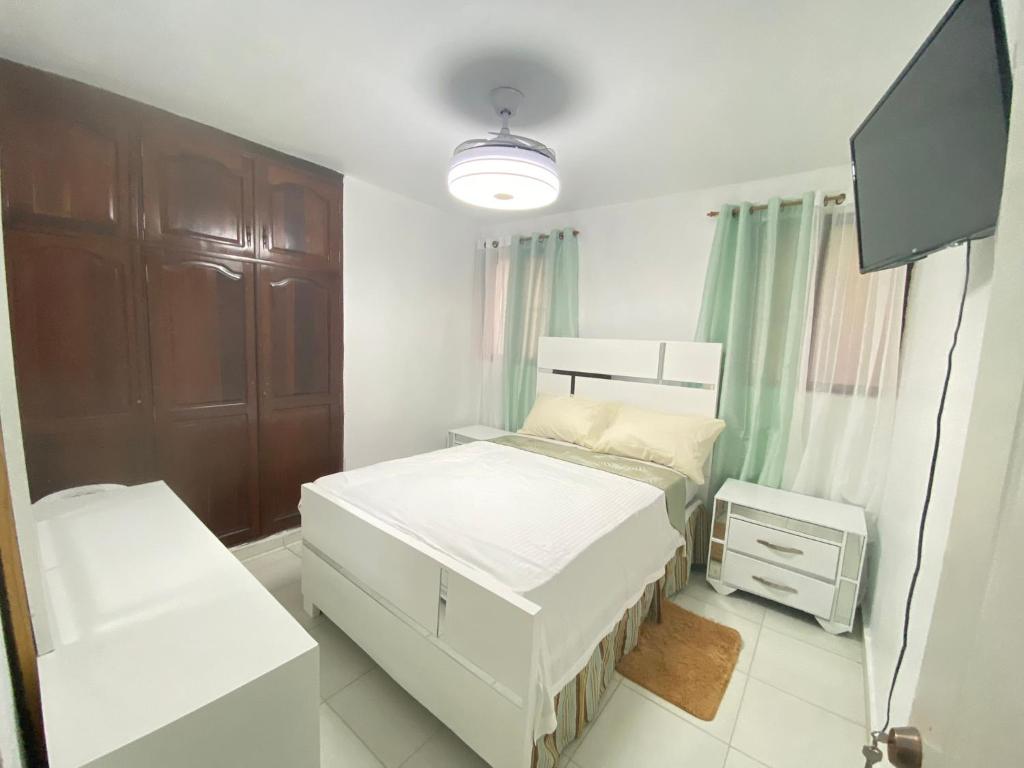 a bedroom with two beds and a flat screen tv at Santiago Monumental Area Cozy 3 bedrooms Apartment for 7 peoples - transportation 24 hours-9 in Santiago de los Caballeros