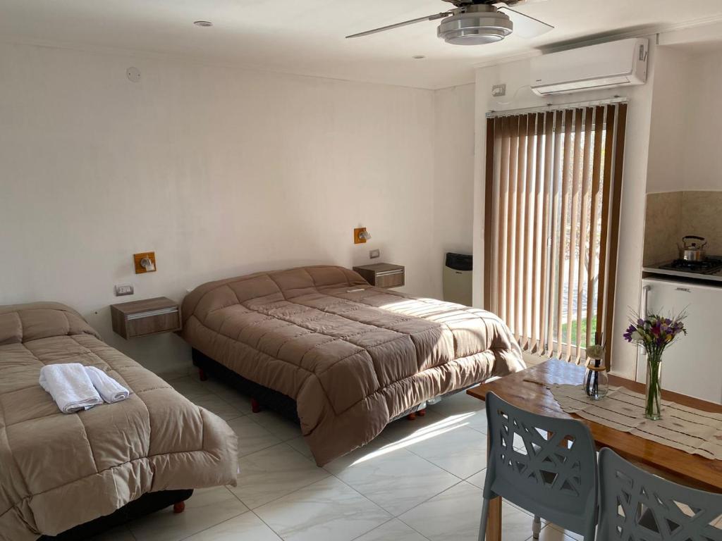 a bedroom with a bed and a table and a window at Apart Los Algarrobos in Marcos Juárez