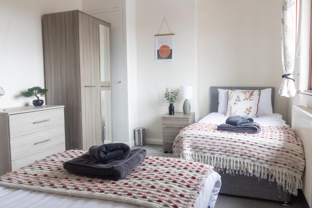 um quarto com 2 camas e toalhas em Adrian House, near Hospital, easy parking + garden em Carlisle