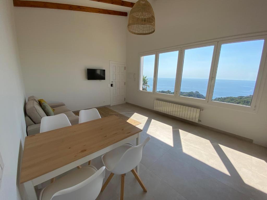 uma sala de jantar com uma mesa de madeira e cadeiras brancas em Loft Casa Blanca em Blanes