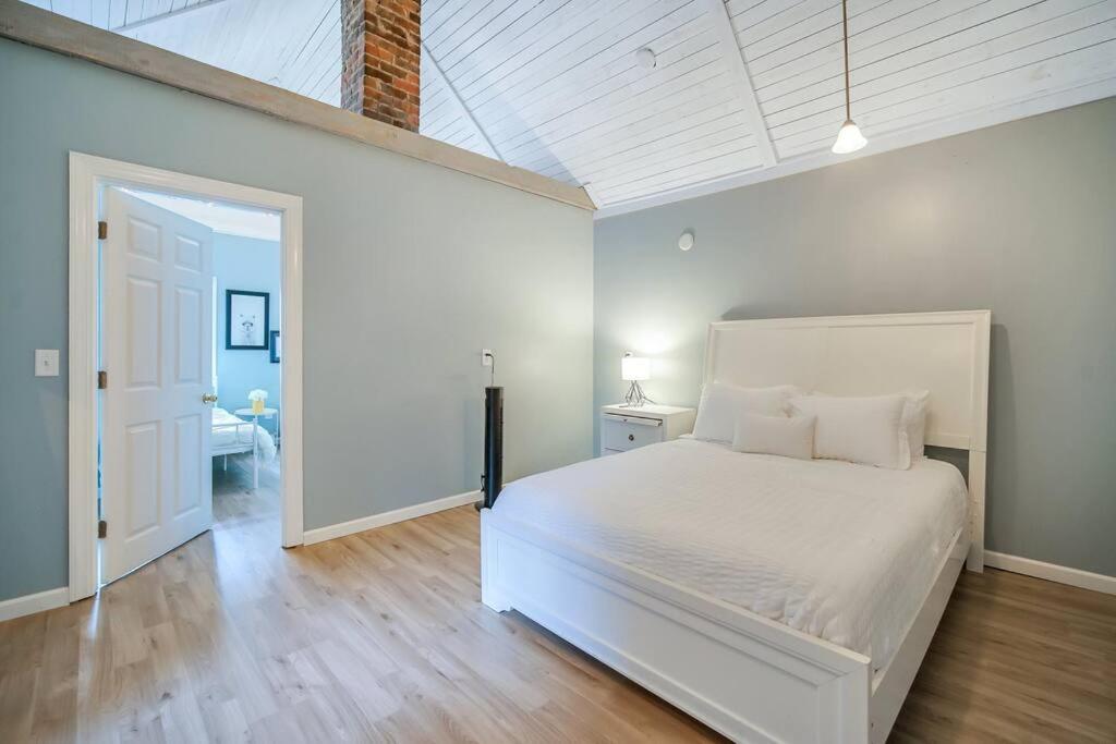 a bedroom with a white bed and a white ceiling at New Cheerful Renovated Home - 5 Min to Downtown! in Savannah