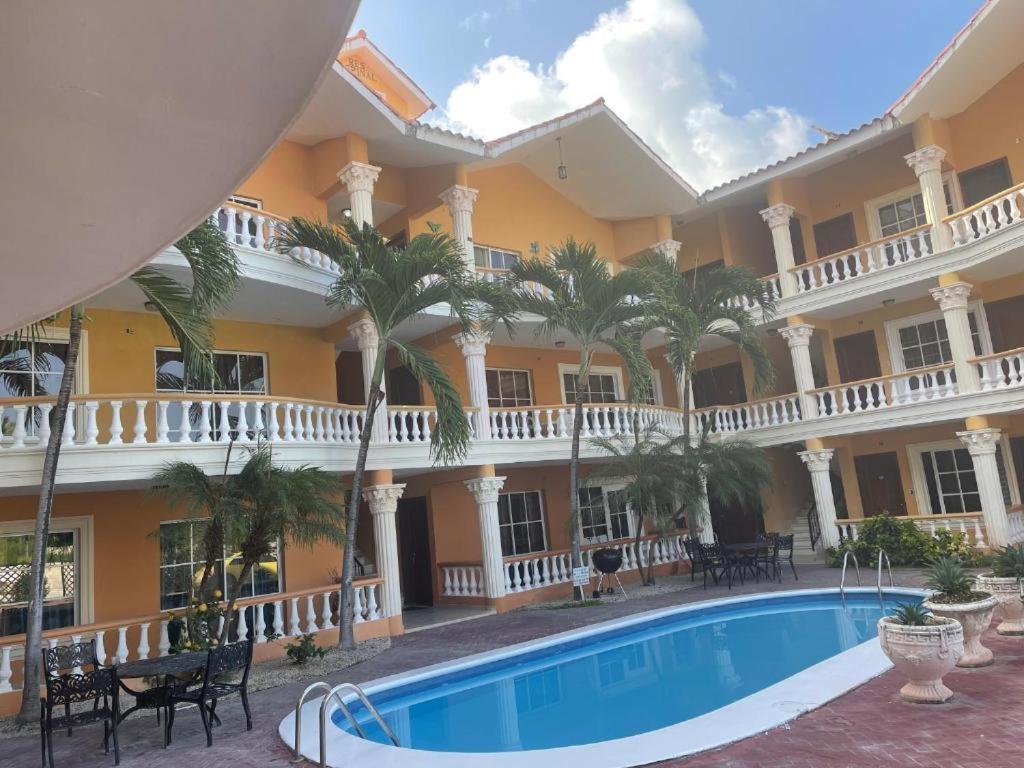 un hôtel avec une piscine en face d'un bâtiment dans l'établissement L&Y Punta Cana Beach Apartament, à Punta Cana