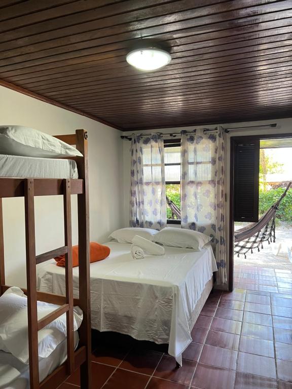 a bedroom with two bunk beds and a window at Pousada Pé Na Areia - ilha do mel in Paranaguá
