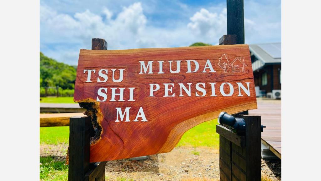 um sinal de madeira que diz tsv mulda st pension ma em Tsushima Miuda Pension em Tsushima