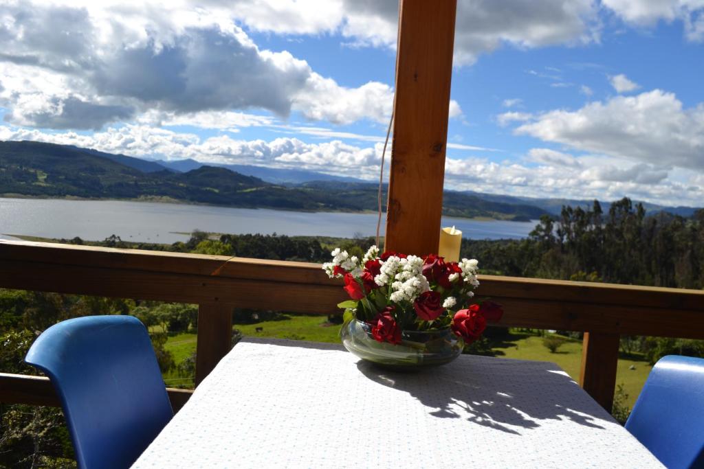 un vaso di fiori seduto su un tavolo sul balcone di Arrecife Glamping a Guatavita