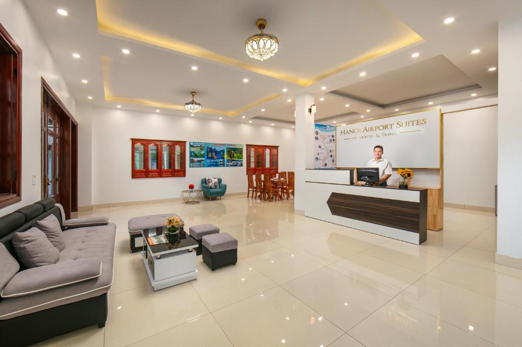 a man standing at a counter in a lobby at Hanoi Airport Suites Hostel & Travel in Hanoi