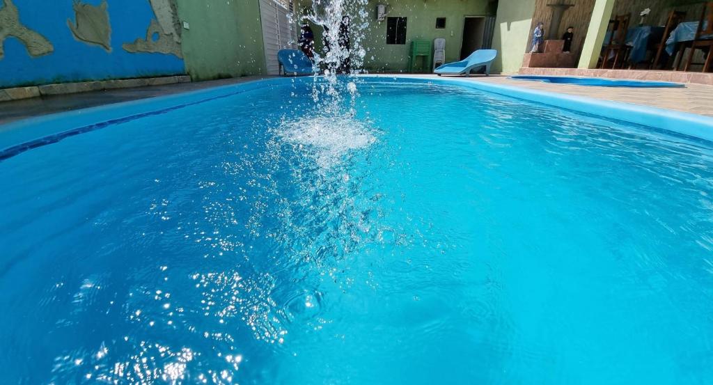 a blue swimming pool with a water fountain at Pousada Nossa Senhora Das Dores in Maragogi