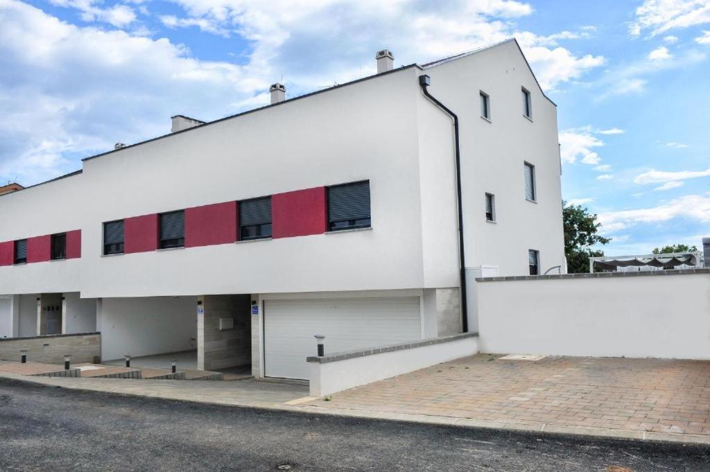 a white building with red windows on the side of it at APARTMENT SECRET GARDEN 3 in Zaton