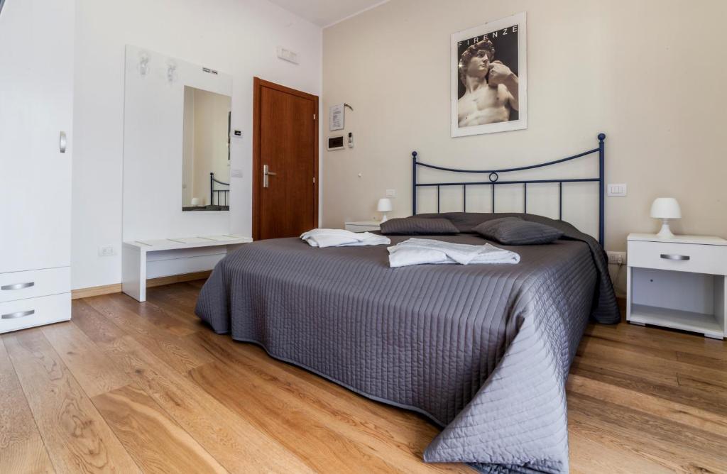 1 dormitorio con 1 cama grande y suelo de madera en Le Ghiacciaie, en Florencia