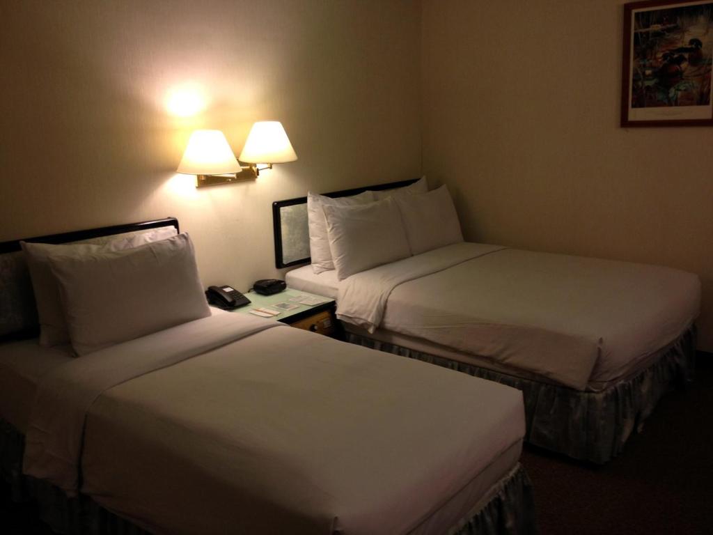 Ein Bett oder Betten in einem Zimmer der Unterkunft The Premier Hotel