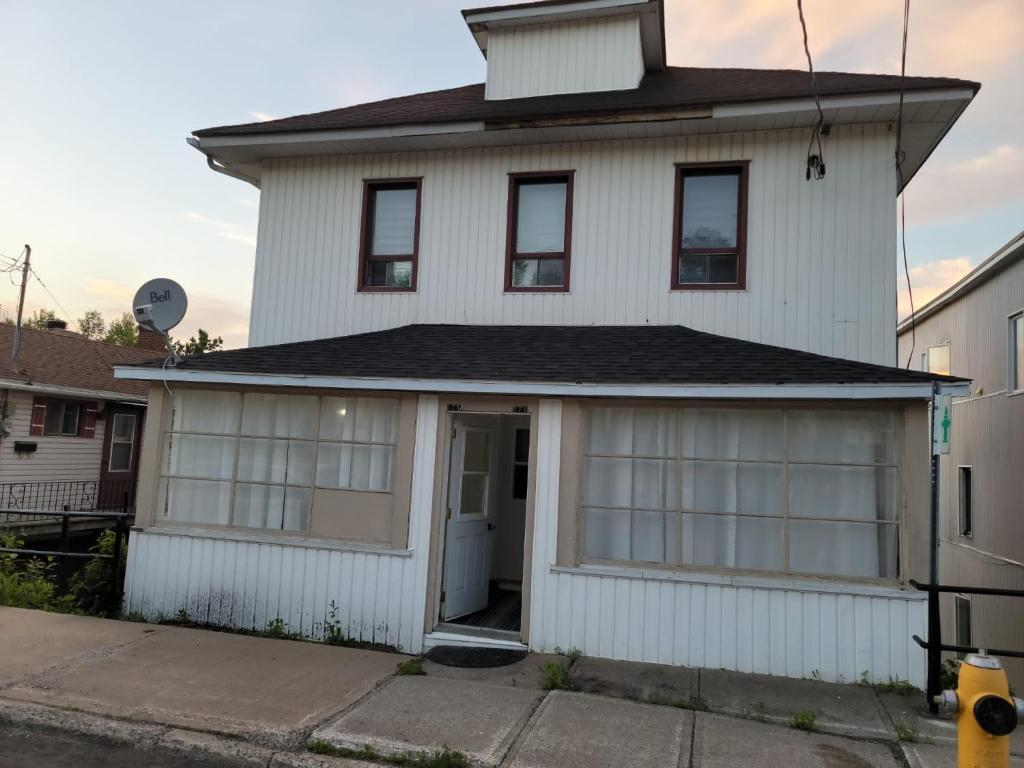 une maison blanche avec un garage pour 2 voitures dans l'établissement Private Home in downtown Edmundston!, à Edmundston