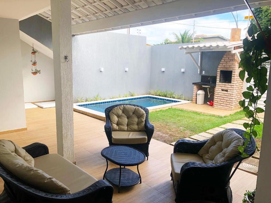 a patio with chairs and a swimming pool at Casa em Peroba/Maragogi 100m da Praia in Ponta do Mangue