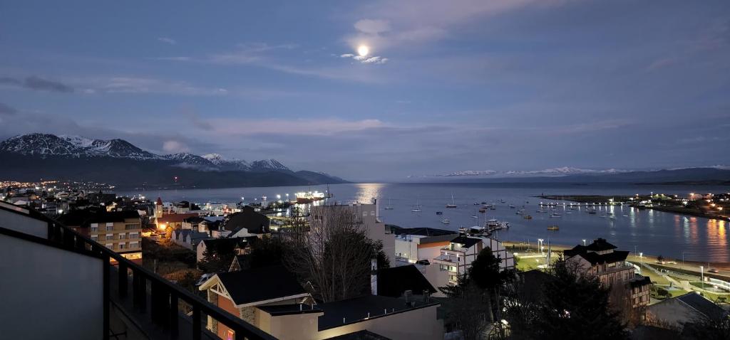 a view of a city at night with a mountain at Pacifico Departamentos in Ushuaia