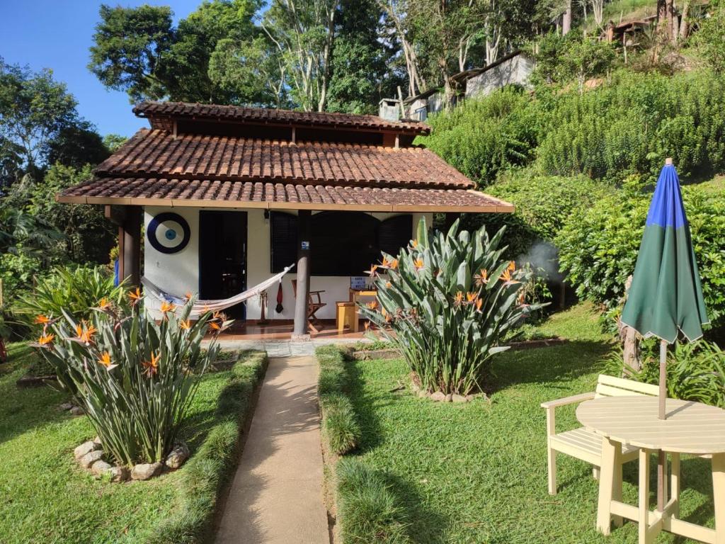 uma casa com uma rede de descanso num jardim em Chalé das Montanhas - Cachoeira particular dentro da hospedagem em Nova Friburgo