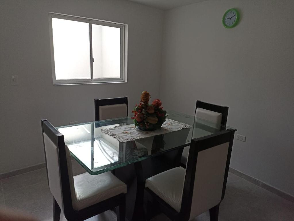 a dining room with a glass table and chairs at Agradable casa para alojamiento completo CURITI in Curití