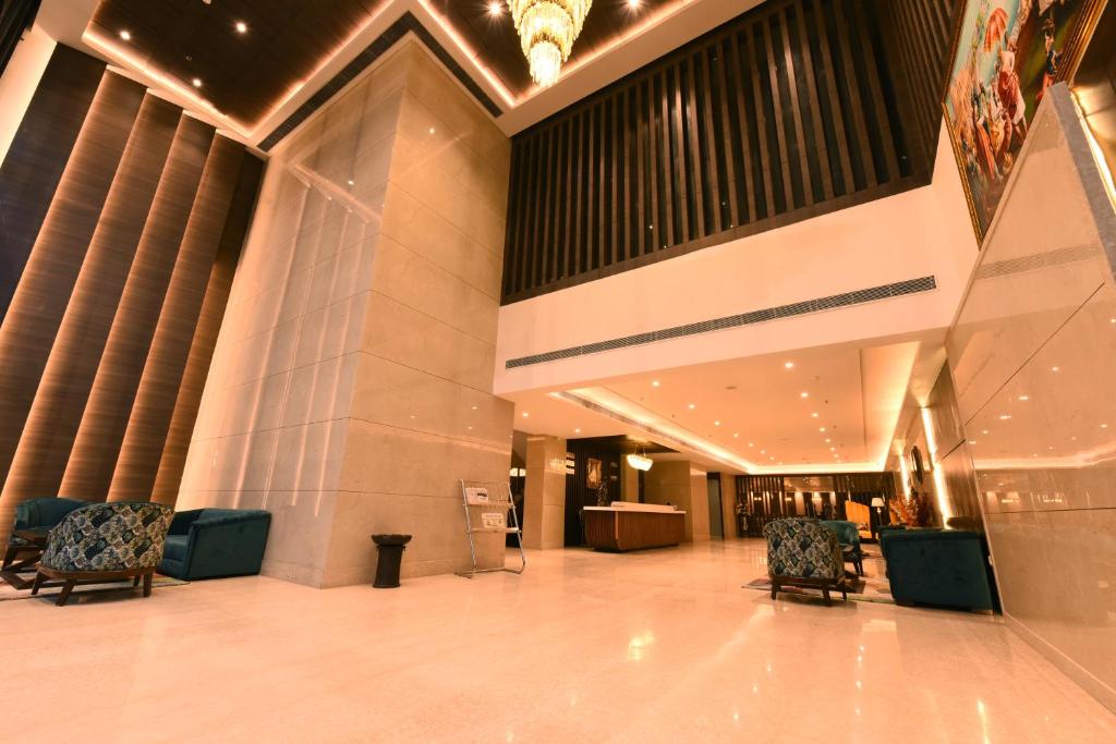 a lobby of a building with chairs and curtains at The Pribson Hotel in Amritsar