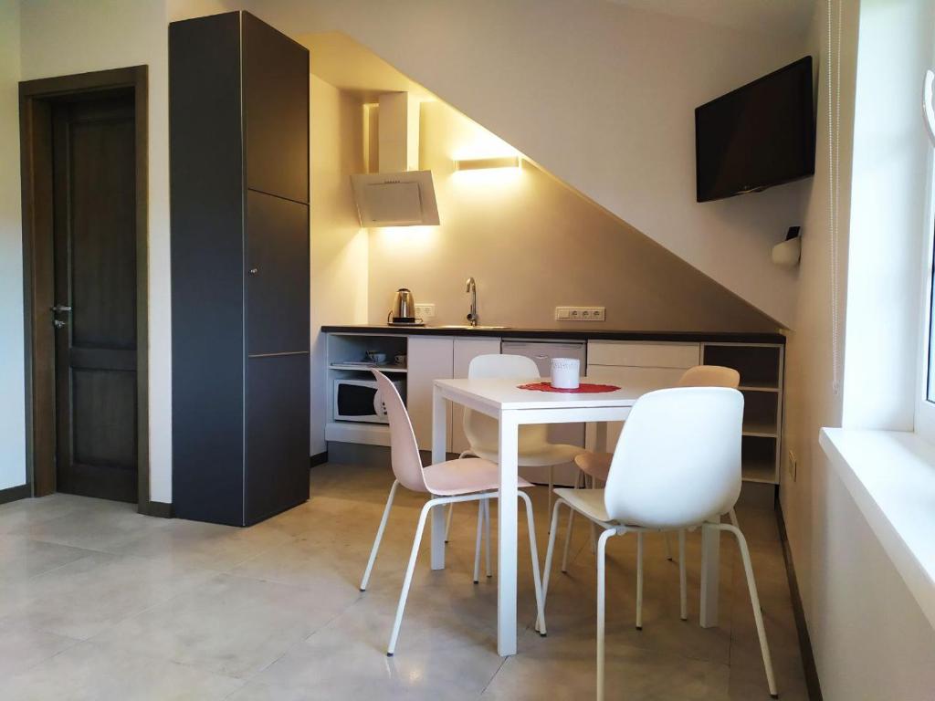 uma cozinha com mesa e cadeiras num quarto em "Trakaitis" apartments & holiday homes em Trakai