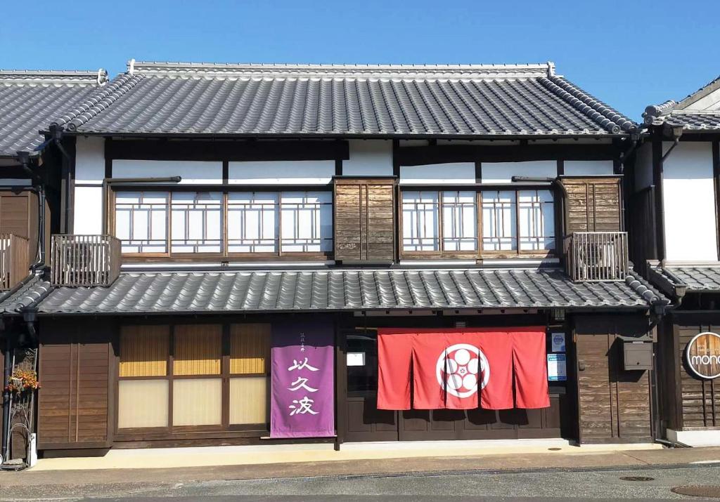 un edificio con banderas colgando en la parte delantera en Chikugo Yoshii Guest House IKUHA - Vacation STAY 00064v, en Ukiha