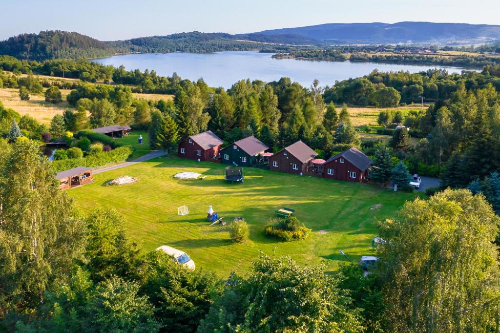 eine Luftansicht eines Hauses auf einem Feld mit See in der Unterkunft Stanica pod Zadzierną Domki całoroczne in Lubawka