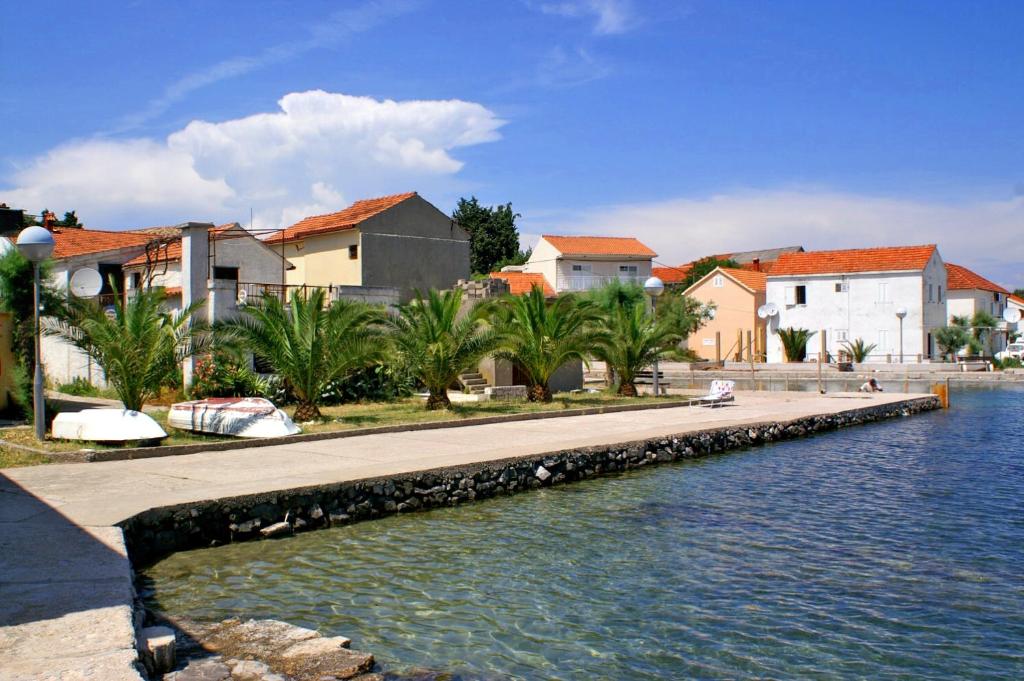 a canal with houses and buildings next to a city at Family Room Drace 4550a in Drače