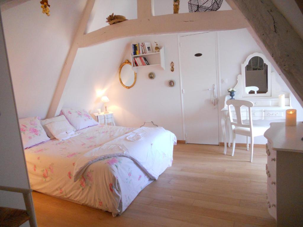 a bedroom with a bed and a table and a chair at chambre d'hotes le nid du phare avec jacuzzi in Honfleur