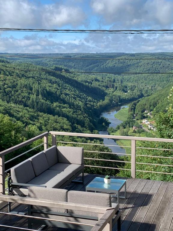 a balcony with a couch and a table and a river at Castorama in Rochehaut