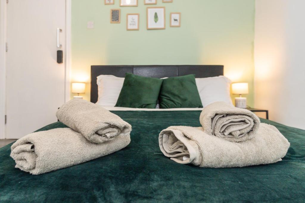 Una cama con toallas encima. en Five Seasons Liverpool City - Modern Studios near Anfield en Liverpool