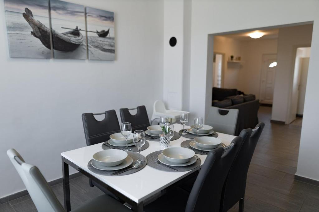 una sala da pranzo con tavolo e sedie bianchi di Olivér 22 Apartman a Fonyód