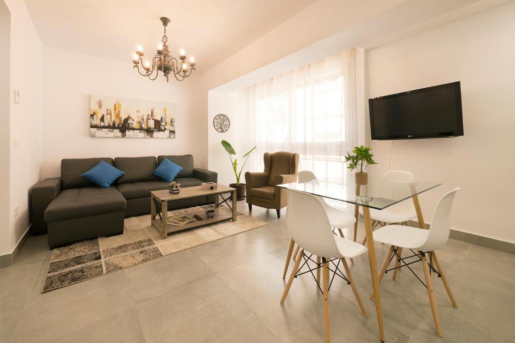uma sala de estar com um sofá e uma mesa em Apartamento Ribera del Genil Centro em Granada