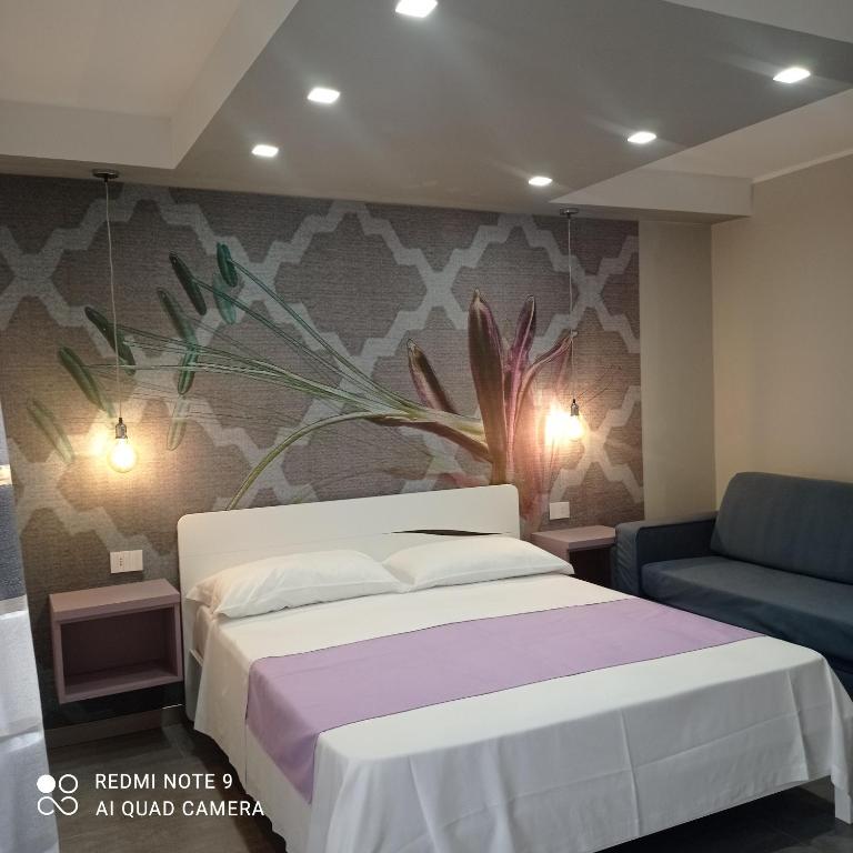 sypialnia z łóżkiem i ścianą z malowidłem kwiatowym w obiekcie Garden Gafè w mieście Diamante