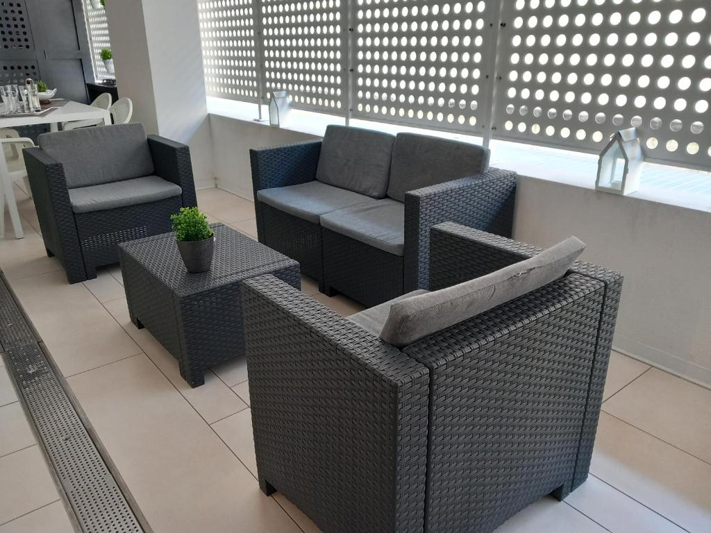 a patio with chairs and a couch and tables at Rome 66 apartments in Rome
