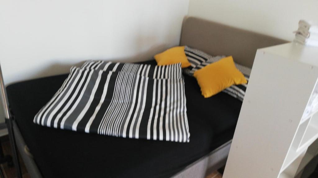 a black bed with two pillows on top of it at Studio apartman Noa in Rijeka