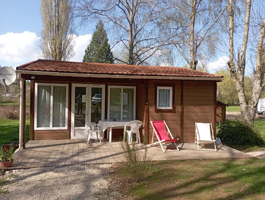 a tiny house with a table and chairs on a patio at Le pré aux sages in Dadonville