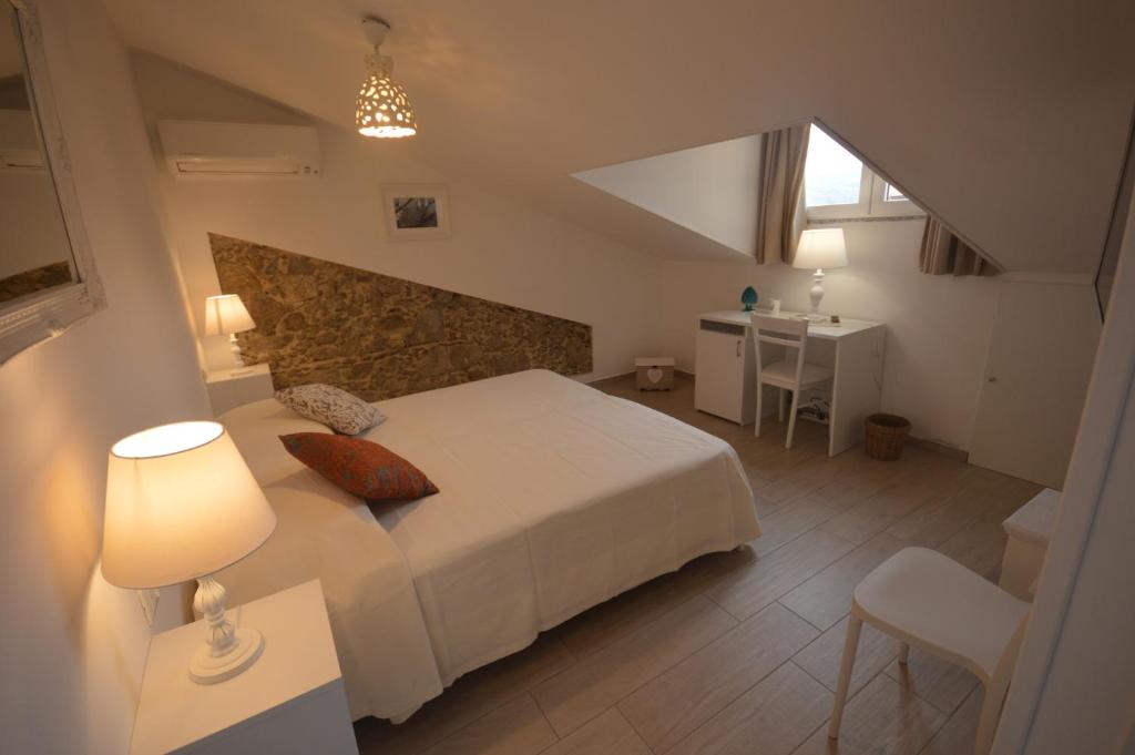 een slaapkamer met een wit bed, een tafel en een wastafel bij B&B Tra Cielo e Mare in Soverato Superiore