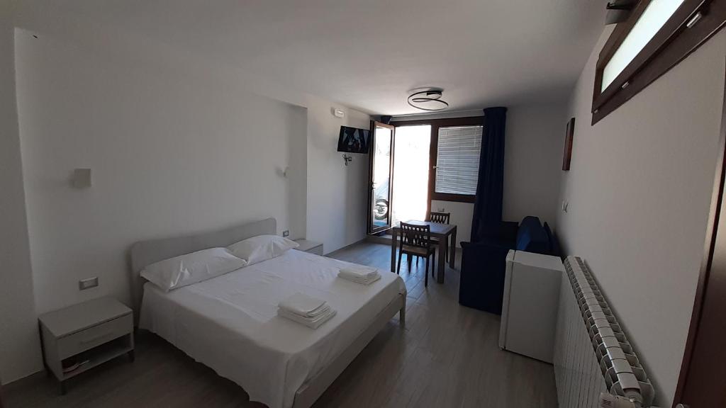 Schlafzimmer mit einem Bett, einem Tisch und einem Fenster in der Unterkunft Villa Saponaro - Affittacamere in Torre Lapillo