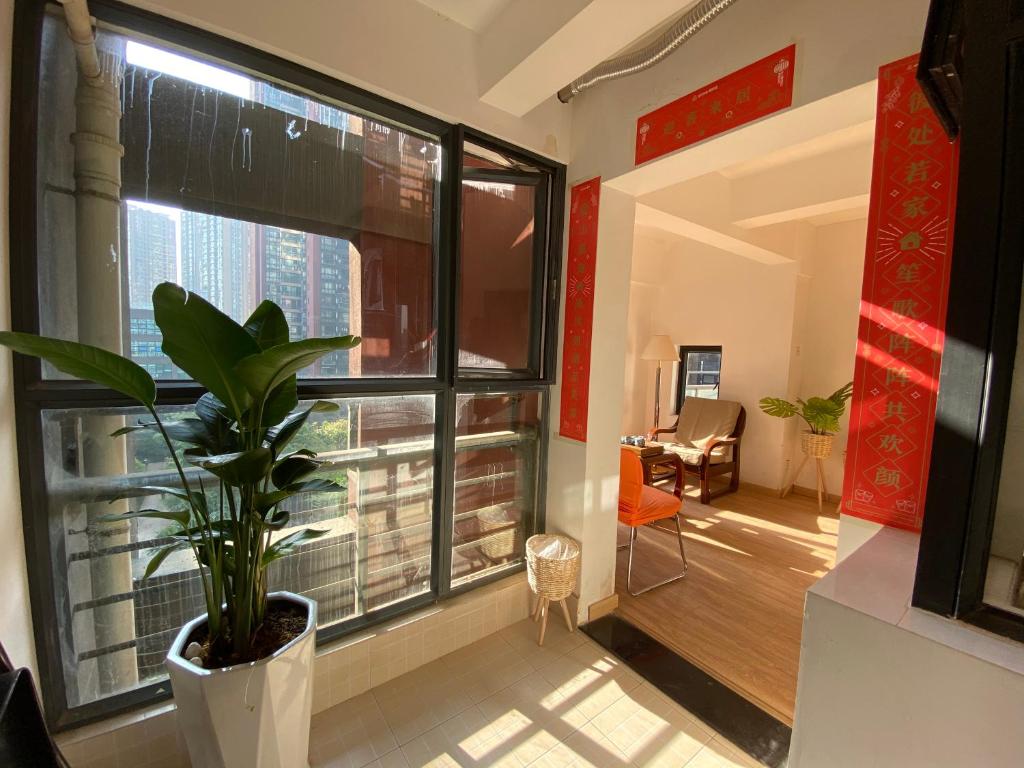 a living room with a large window and a plant at 合家欢 in Kunming