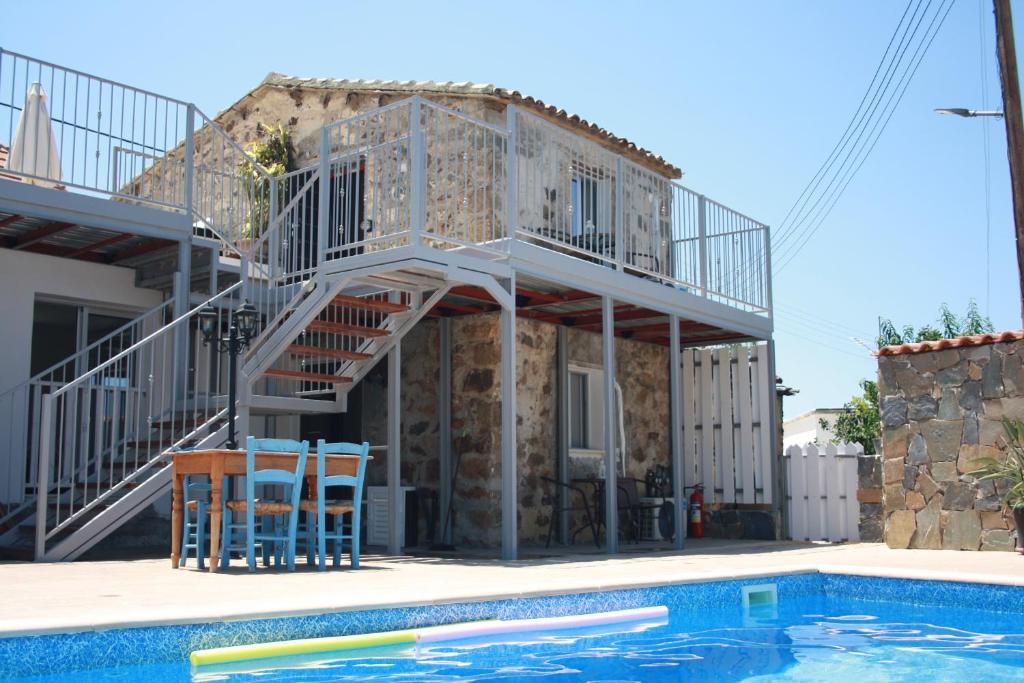 a house with a staircase next to a swimming pool at Holiday Apartments,Polynikis Sea-Cret, Pachyammos in Pachyammos