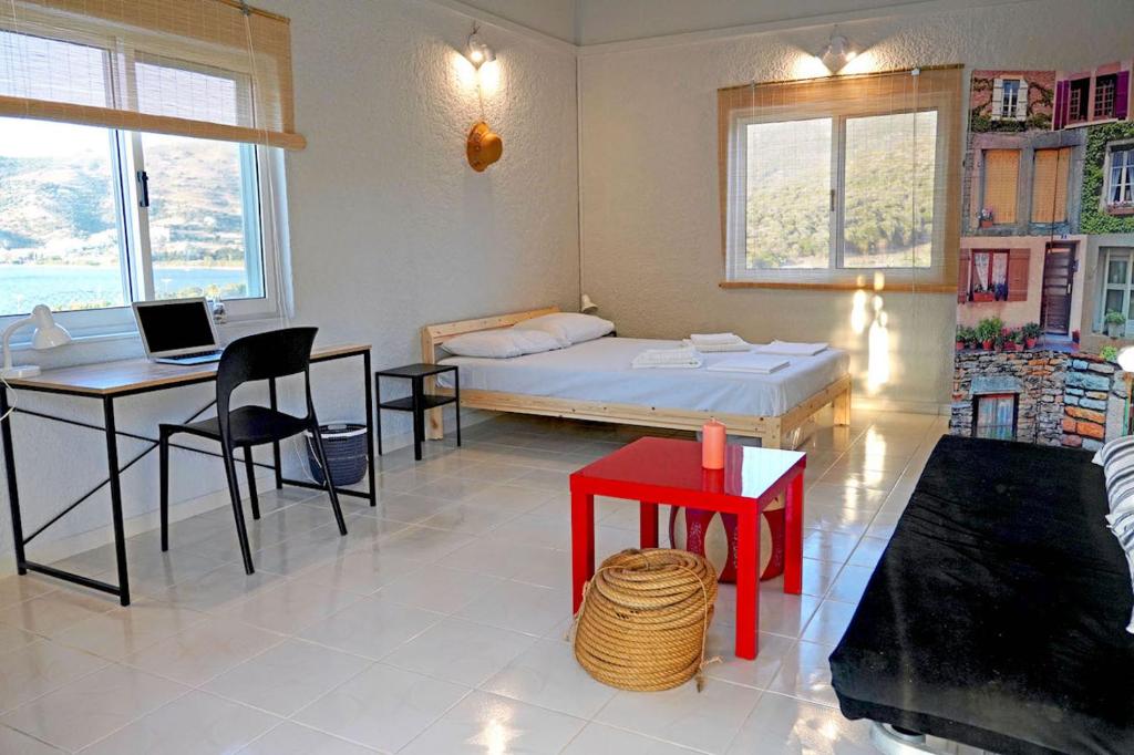 een slaapkamer met een bed, een tafel en een bureau bij Figs & Grapes * Cosy small house * Marmari * South Evia in Marmarion
