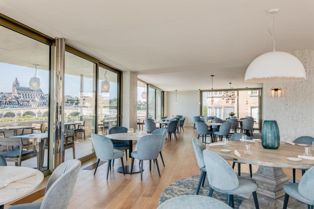 a restaurant with tables and chairs and a view of the city at Fleur de Loire in Blois