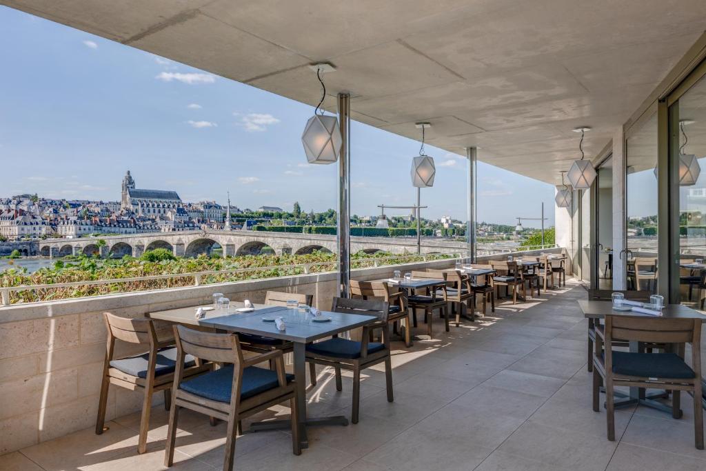 a restaurant with tables and chairs and a view of the city at Fleur de Loire in Blois