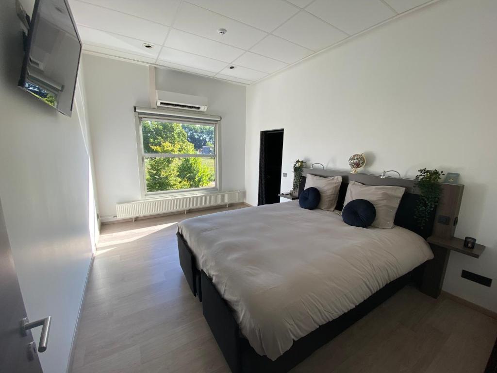 a bedroom with a large bed and a window at De Wellnessloft Bocholt in Bocholt