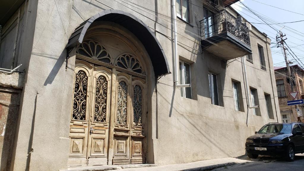 Family Guest House في تبليسي: مبنى عليه باب خشبي كبير