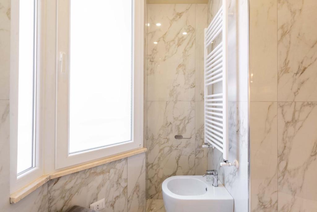 a white bathroom with a sink and a window at ELICAL Exclusive Private Suites in Rome