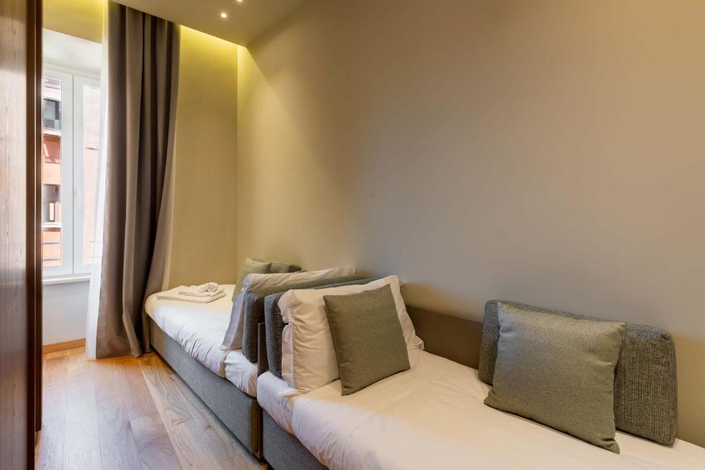a room with two beds with pillows on them at ELICAL Exclusive Private Suites in Rome